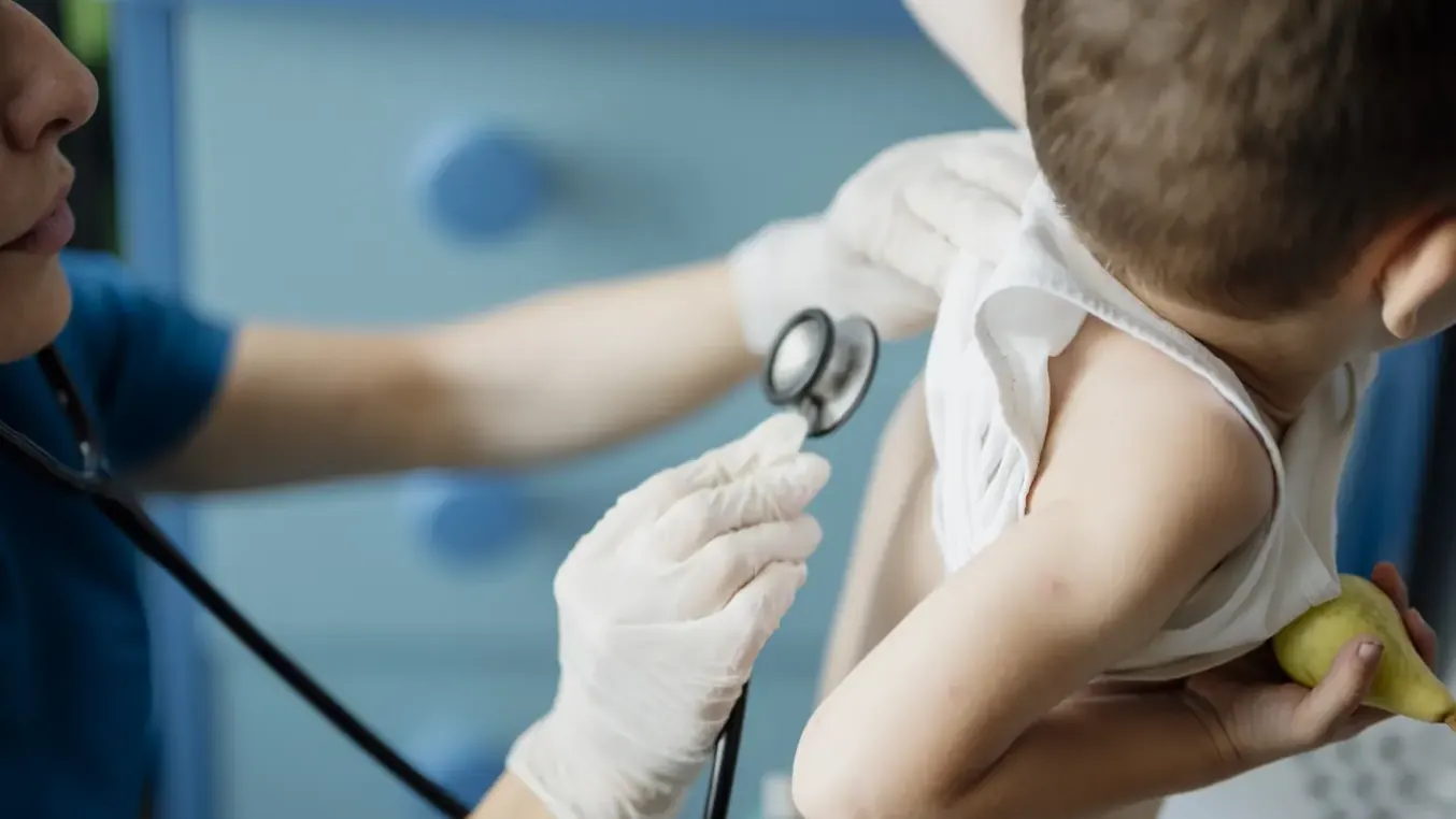 Un enfant ausculté au stéthoscope lors d’une consultation.